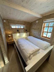 a bedroom with a bed in a wooden cabin at Holiday cottage with sauna close to Kjerag in Tjørhom