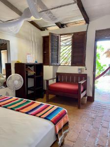 a bedroom with two beds and a red bench at Posada Mexico in Zipolite