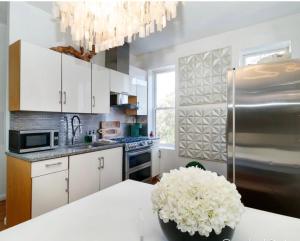 una cucina con armadi bianchi e un vaso di fiori su un tavolo di A Dedicated Space To Unwind a Brooklyn
