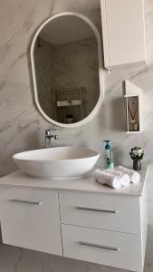 a white bathroom with a sink and a mirror at Marbella Resort in Al Ain