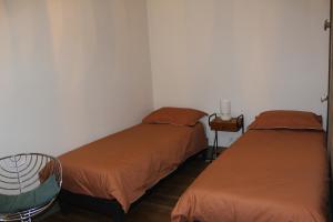 a room with two beds and a chair in it at La Riveraine et les bicyclettes in Saint-Sauveur-de-Montagut