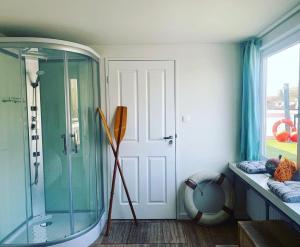 een badkamer met een douche en een glazen deur bij Amster Houseboat Bed without Breakfast in Amsterdam
