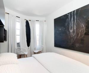 布魯克林的住宿－A Dedicated Space To Unwind，卧室配有白色的床和2把椅子