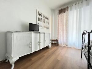 a white dresser with a tv on it in a room at Porta Amari B&B in Palermo
