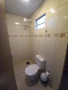 La salle de bains blanche est pourvue de toilettes et d'une fenêtre. dans l'établissement Hotel em SBO - São Francisco, à Santa Bárbara dʼOeste