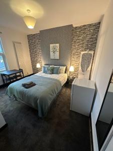a bedroom with a bed and a brick wall at 10 Minutes to Central London Vaux in London