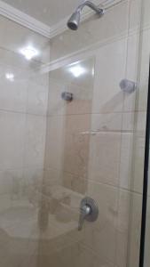 um chuveiro com uma porta de vidro na casa de banho em Atlântica Hotel 5 estrelas - Coração da Faria Lima em São Paulo