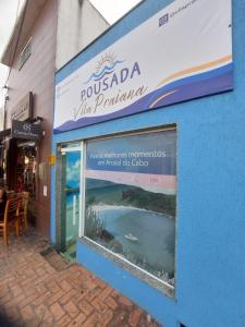 un edificio con una señal para una villa con paraíso en Pousada Vila Praiana, en Arraial do Cabo