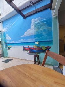 mural de una playa con dos barcos en una pared en Pousada Vila Praiana, en Arraial do Cabo
