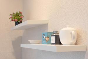 a shelf with a tea pot and other items on it at Queenstown Modern Studio at Arthurs Point in Queenstown