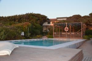 una piscina con pérgola junto a una casa en Il Delfinetto, en San Vincenzo