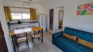a living room with a blue couch and a table at Cabañas Nakupenda in Villa Carlos Paz