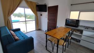 - un salon avec une table et un canapé bleu dans l'établissement Cabañas Nakupenda, à Villa Carlos Paz