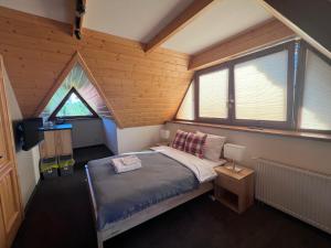 a small bedroom with a bed in a attic at Miętusi Dwór in Zakopane