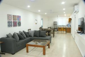 a living room with a couch and a table at Edifico con departamentos amplios cerca de la playa in Puerto Morelos