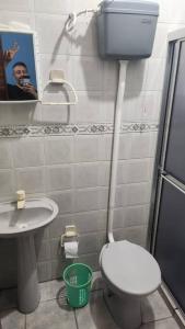 Ein Mann fotografiert ein Bad mit WC und Waschbecken in der Unterkunft Apartamento de 6a8 P Churrasqueira in Cidreira