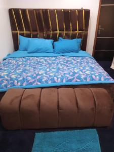 a bed with a blue comforter and blue pillows at cozy comforts in Lagos