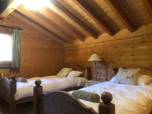 a bedroom with two beds in a log cabin at Chalet La piste du Linga in Châtel