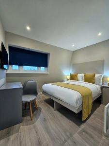 Schlafzimmer mit einem Bett, einem Schreibtisch und einem Fenster in der Unterkunft BOKA Earls Court in London