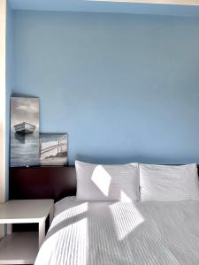 ein Schlafzimmer mit einem weißen Bett und einer blauen Wand in der Unterkunft J house 拉法民宿 in Taitung