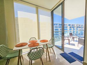 una mesa y sillas en una habitación con balcón en Apartamento 2 habitaciones en Morros Zoe frente al mar en Cartagena., en Cartagena de Indias