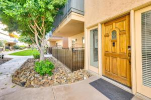 a house with a wooden door and a tree at Private Patio, Community Perks Palm Springs Condo in Palm Springs