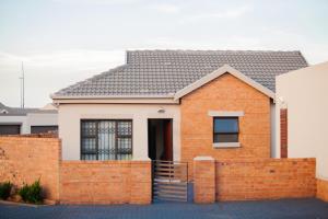 a brick house with a fence in front of it at Marelden security estate in eMalahleni