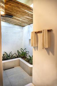a bathroom with two towels hanging on a wall at Awe Villa Boutique Trancoso in Trancoso