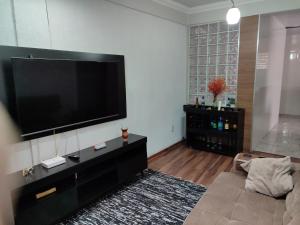 欧鲁普雷图Aconchegante Apartamento em Ouro Preto的客厅配有壁挂式大屏幕平面电视