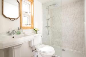 a bathroom with a toilet and a sink and a shower at Hazel - Connect to the Nature in the Hot tub in Blandford Forum