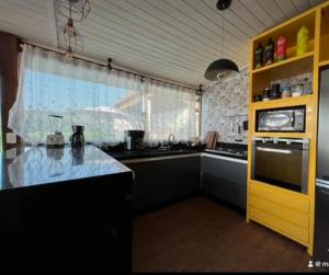 uma cozinha com um balcão e um armário amarelo em Chácara chalé com piscina 30min de SP em Itu