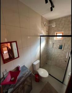 uma casa de banho com um WC e uma cabina de duche em vidro. em Chácara chalé com piscina 30min de SP em Itu