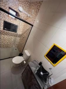 uma casa de banho com um WC e uma mesa de vidro em Chácara chalé com piscina 30min de SP em Itu