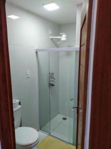 a bathroom with a glass shower with a toilet at Apart Ponta Verde in Maceió
