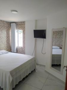 a bedroom with a bed and a mirror and a television at Apart Ponta Verde in Maceió