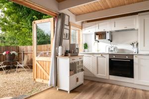 a kitchen with a door open to a patio at Hazel - Connect to the Nature in the Hot tub in Blandford Forum