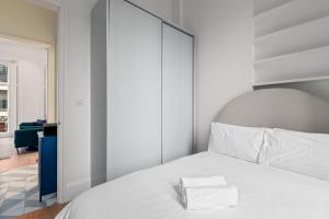 a bedroom with a white bed with a large headboard at Londwell, Central Chic, Luxury Stay by Hyde Park in London