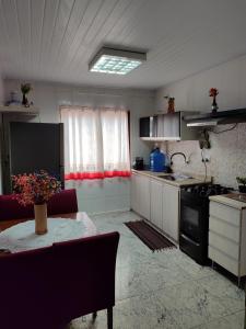 una cucina con tavolo e piano cottura forno superiore di Aconchegante Apartamento em Ouro Preto a Ouro Preto