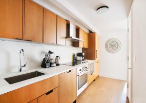 una cocina con armarios de madera y fregadero en Unique Studio Apartment At East Side en Nueva York
