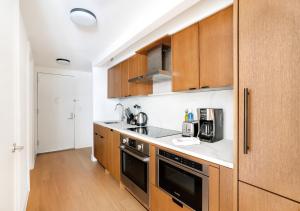 a kitchen with wooden cabinets and a stove top oven at Unique Studio Apartment At East Side in New York