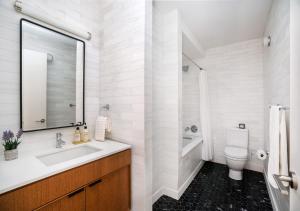 a white bathroom with a sink and a toilet at Unique Studio Apartment At East Side in New York