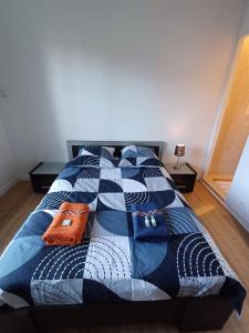 Una cama con un edredón azul y blanco. en l'auberge agenaise de 1 a 8 personnes, en Agen