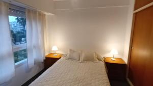 a bedroom with a white bed with two lamps on it at DEPTO 2 Y 62 CON COCHERA PROPIA in La Plata
