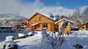 Cabaña de madera con nieve en el suelo en Chalet exposition plein sud, en Xonrupt-Longemer