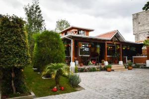 una casa con un jardín delante de ella en Cabaña Don Pacho, en Otavalo