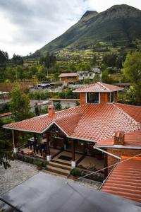 einen Blick über ein Haus mit einem Berg im Hintergrund in der Unterkunft Cabaña Don Pacho in Otavalo