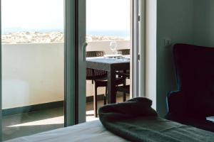 Habitación con mesa y vistas a un balcón. en Sea View Baleal en Peniche