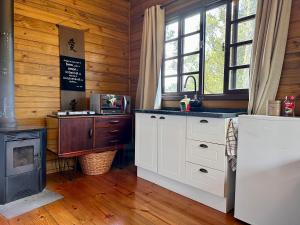 cocina con armarios blancos y fogones en una habitación en Namastê - Hospedaria de Altitude, en Urubici