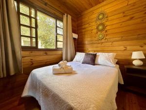 a bedroom with a bed with a teddy bear on it at Namastê - Hospedaria de Altitude in Urubici