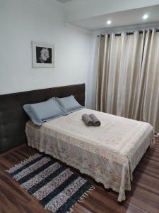 a bedroom with a bed with two shoes on it at Aconchegante Apartamento em Ouro Preto in Ouro Preto